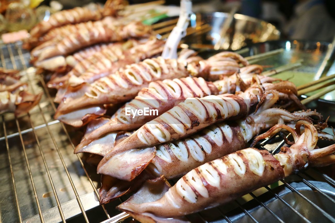 Squid full body with egg inside grill on the stove. grilled squid skewers. delicious street seafood. 