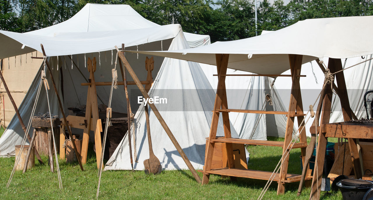 SCENIC VIEW OF TENT ON FIELD SEEN FROM WOODEN POST