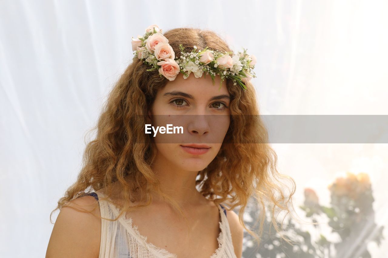 Close-up portrait of woman with flowers in hair