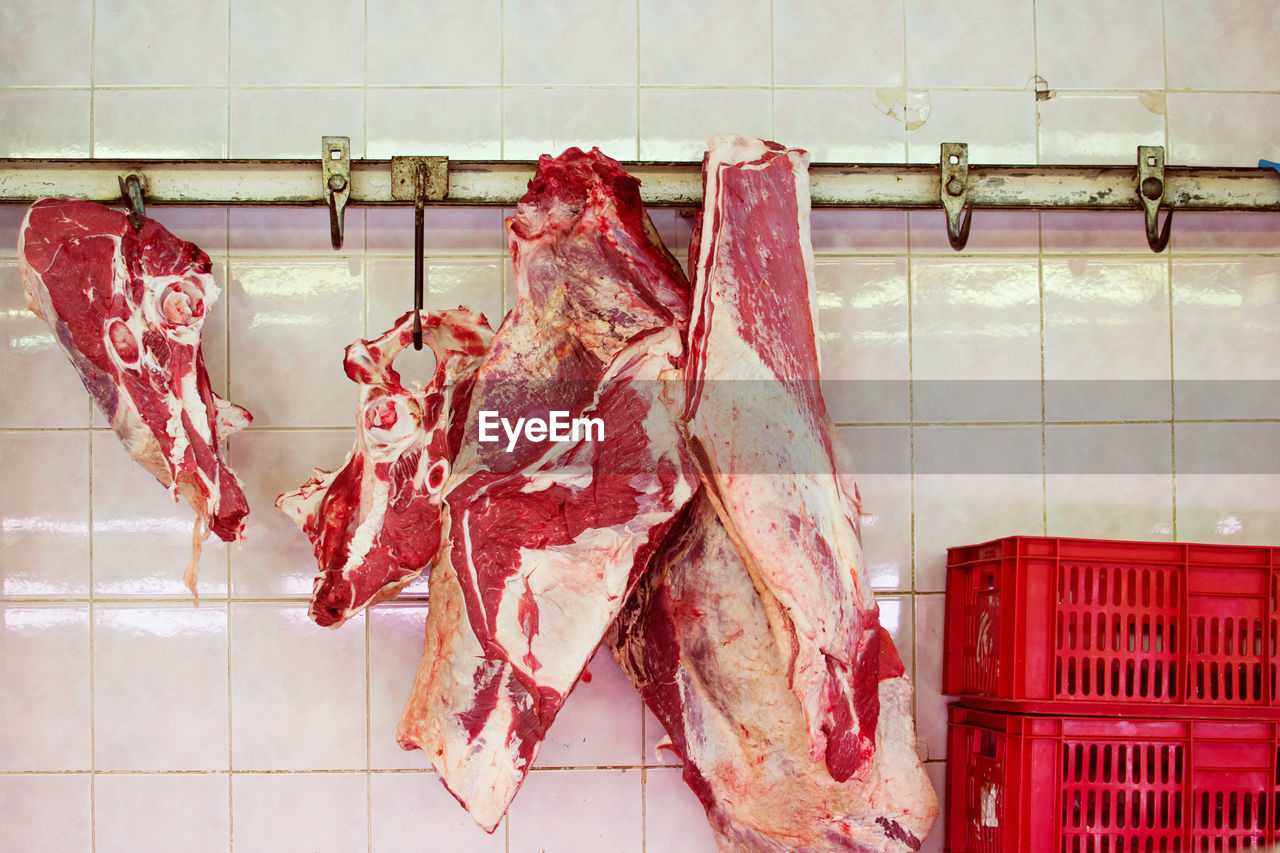 High angle view of meat hanging on wall at market for sale