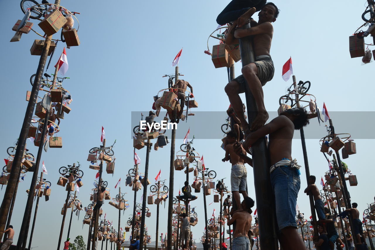 LOW ANGLE VIEW OF PEOPLE AT CONCERT AGAINST SKY