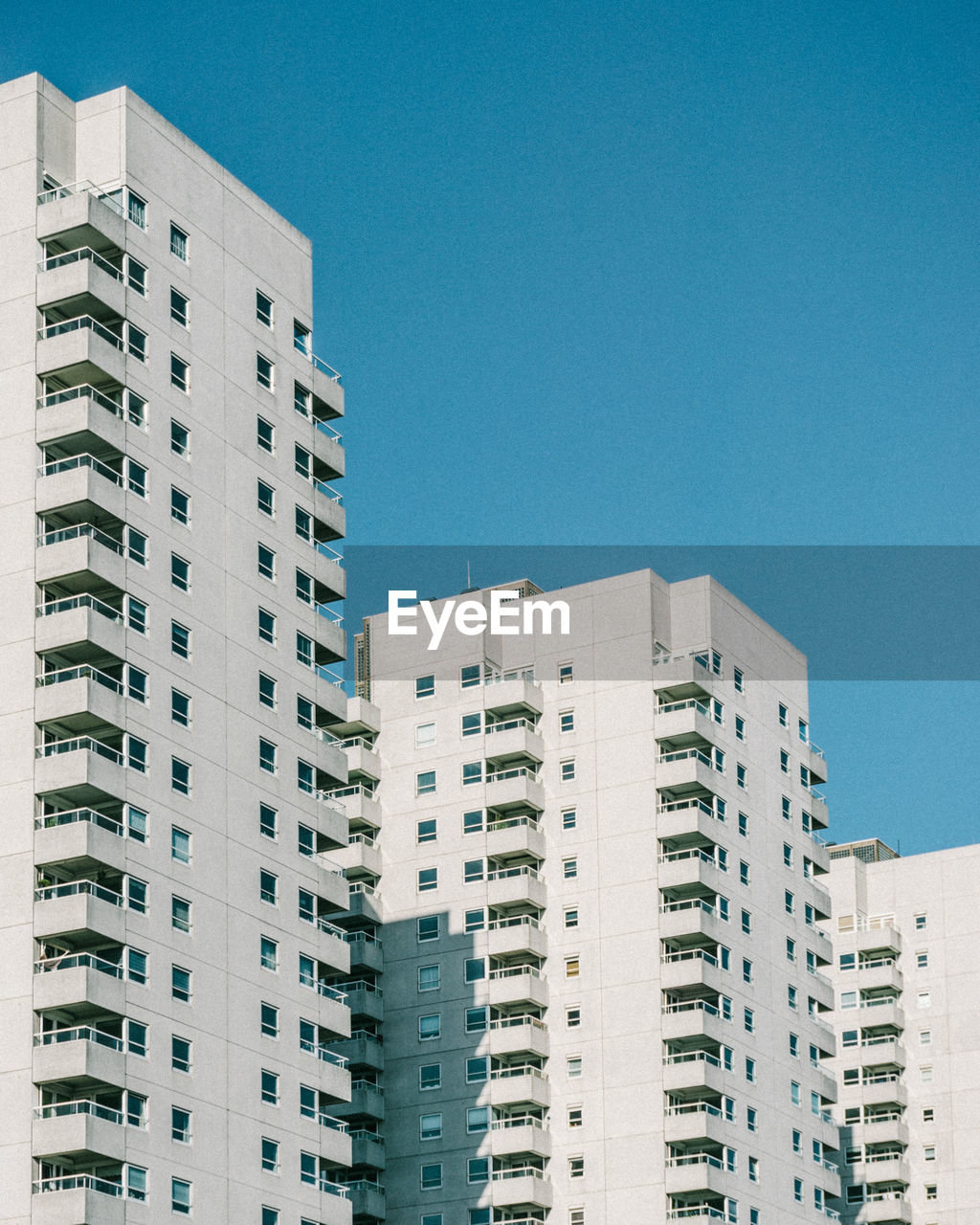 LOW ANGLE VIEW OF MODERN BUILDINGS AGAINST BLUE SKY