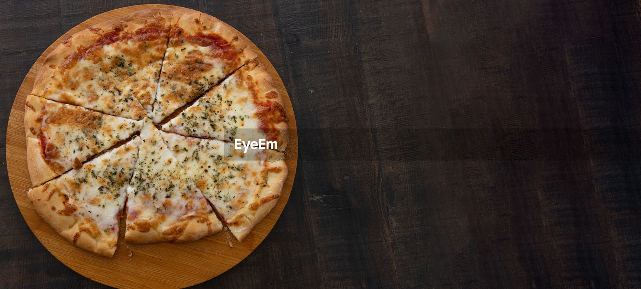 Tasty 4 cheese pizza on a wooden base