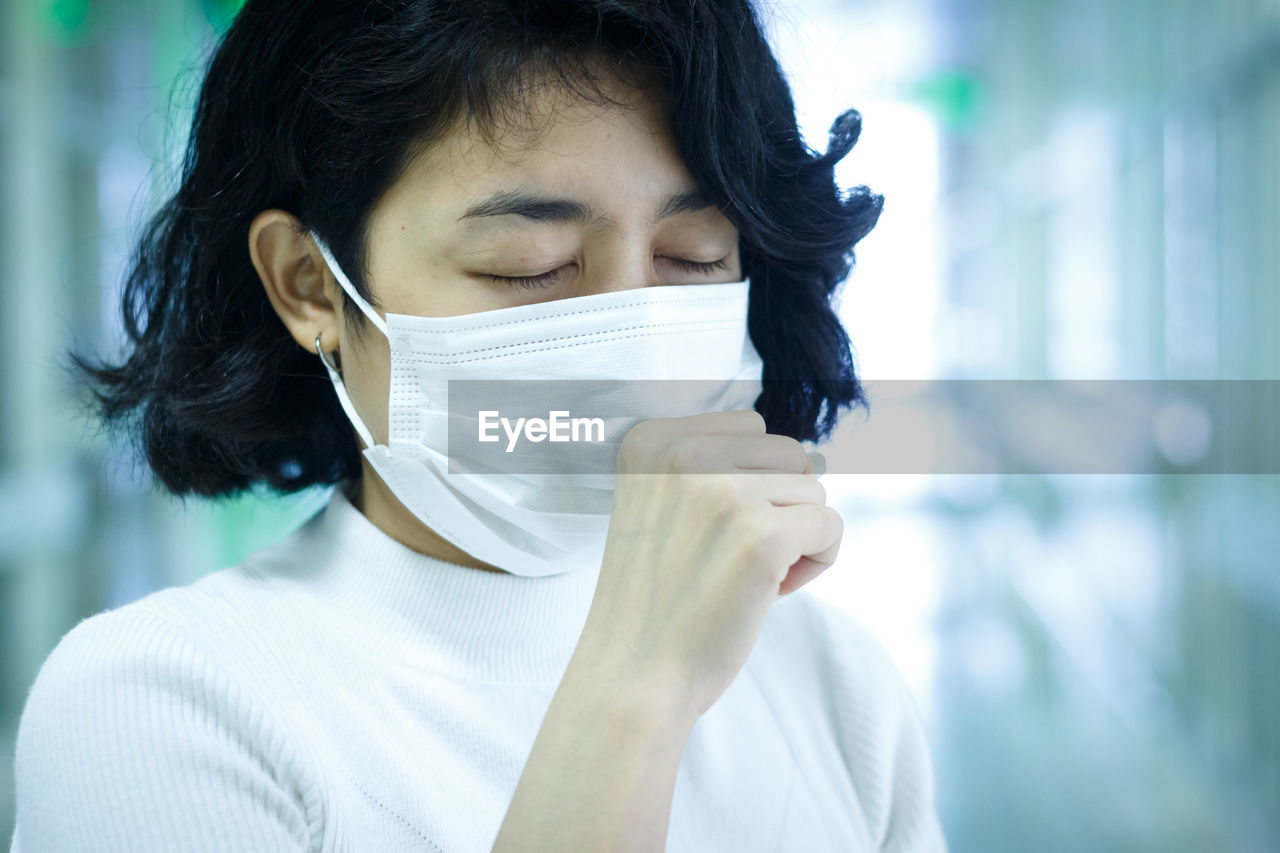 Close-up of sick woman wearing mask