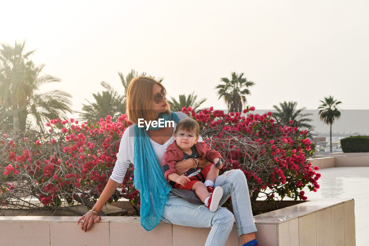 Beautiful young woman walks with a child in the city. motherhood is joy. mother and son