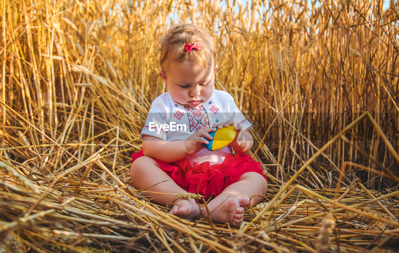 Portrait of cute girl sitting on hay