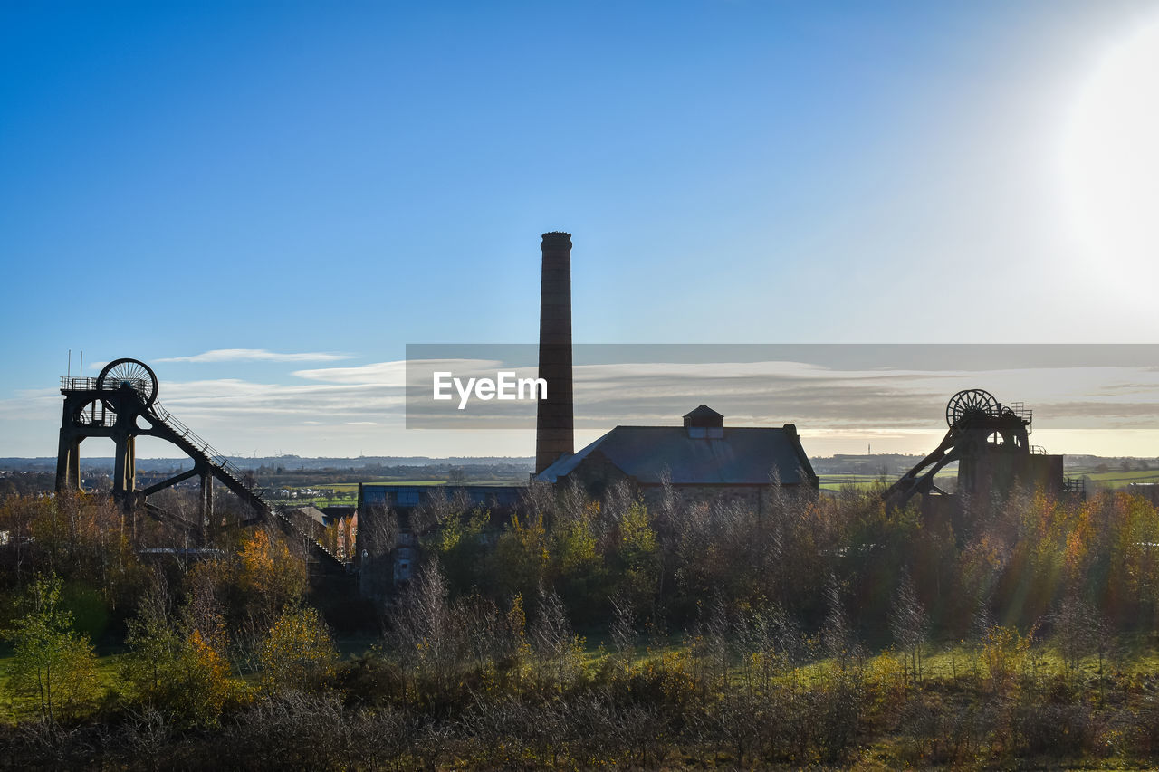 sky, nature, architecture, horizon, morning, built structure, plant, landscape, no people, sunlight, blue, environment, grass, cloud, land, hill, outdoors, clear sky, scenics - nature, building exterior, day, rural area, water, tranquility, sunny, tree, sun, beauty in nature, reflection, field, sea, copy space