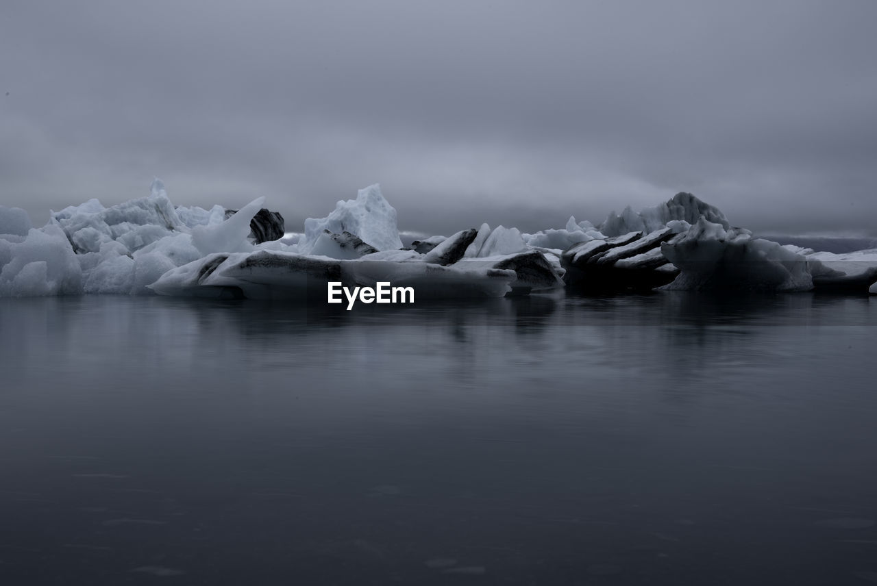 Scenic view of frozen lake against sky iceberg