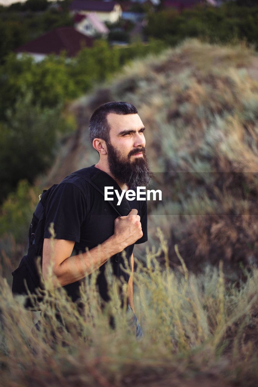 Portrait of a man with a beard on the background of nature and mountains