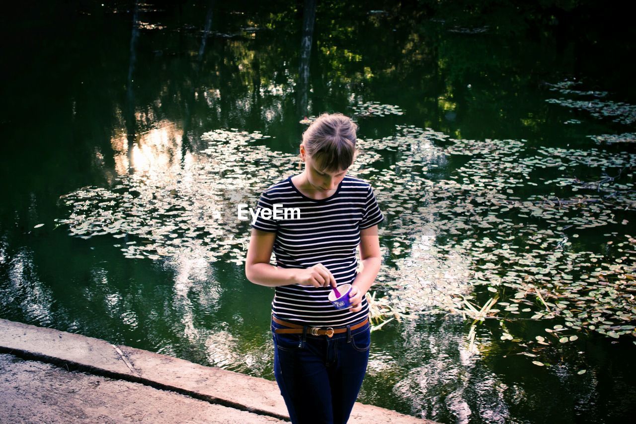 Portrait of young woman by pond