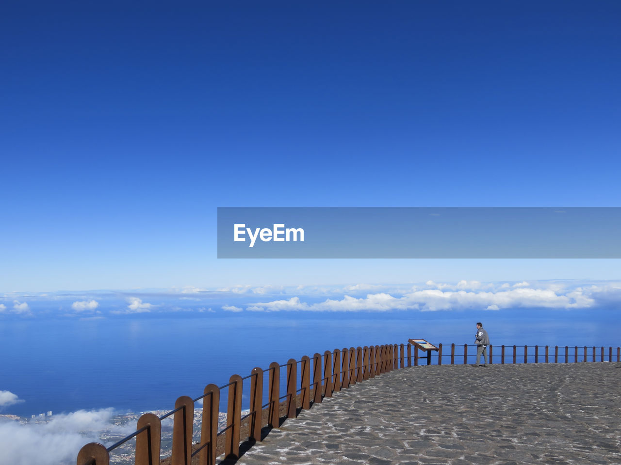 Man standing on observation point looking at sea against clear blue sky in tenerife