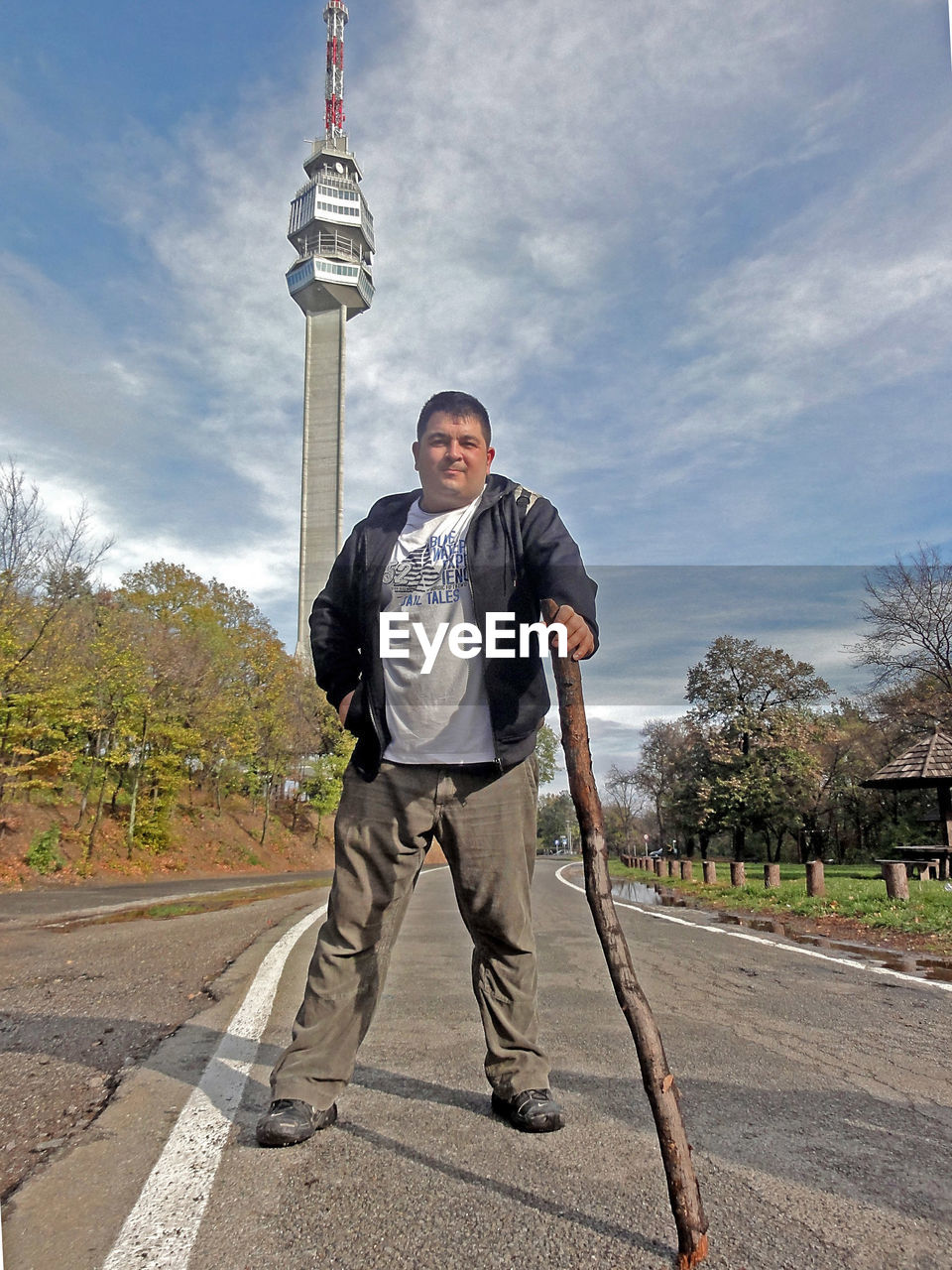 Full length portrait of man standing in city against sky