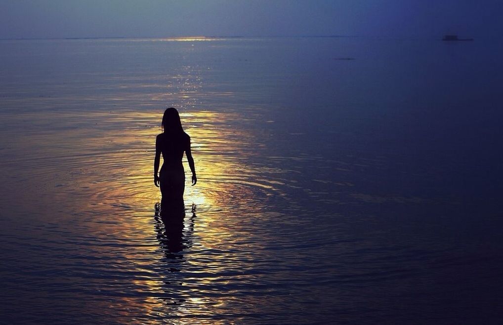 Silhouette of woman in sea