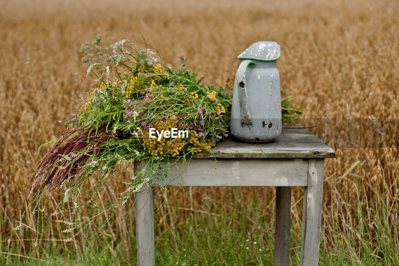 Meadow flowers bouquet and old vase.