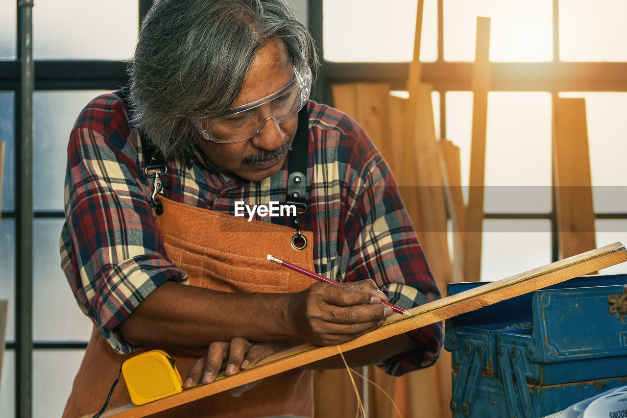 MAN WORKING ON WOOD IN CONTAINER