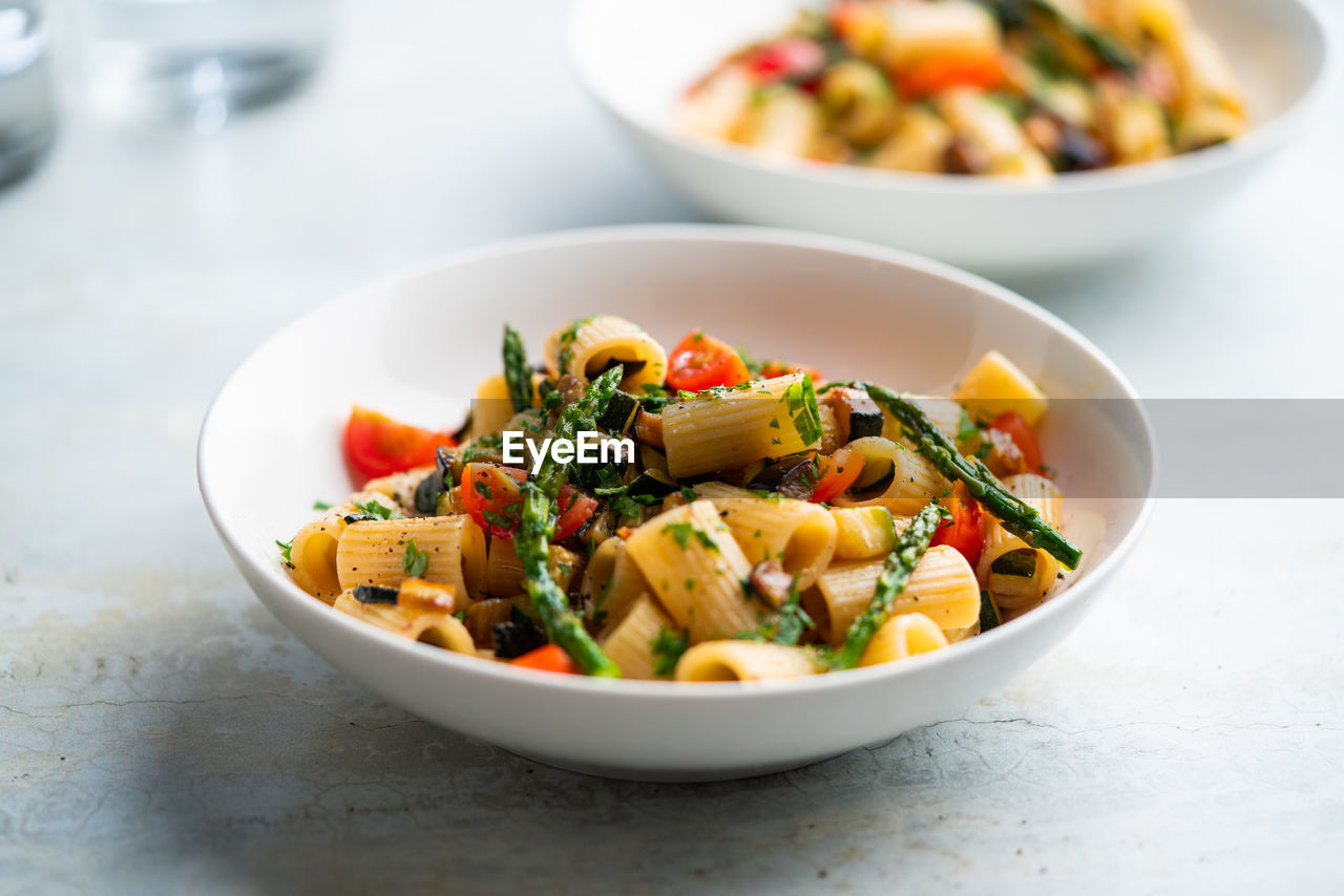 Pasta salad with grilled vegetables, zucchini, eggplant, asparagus and tomatoes.