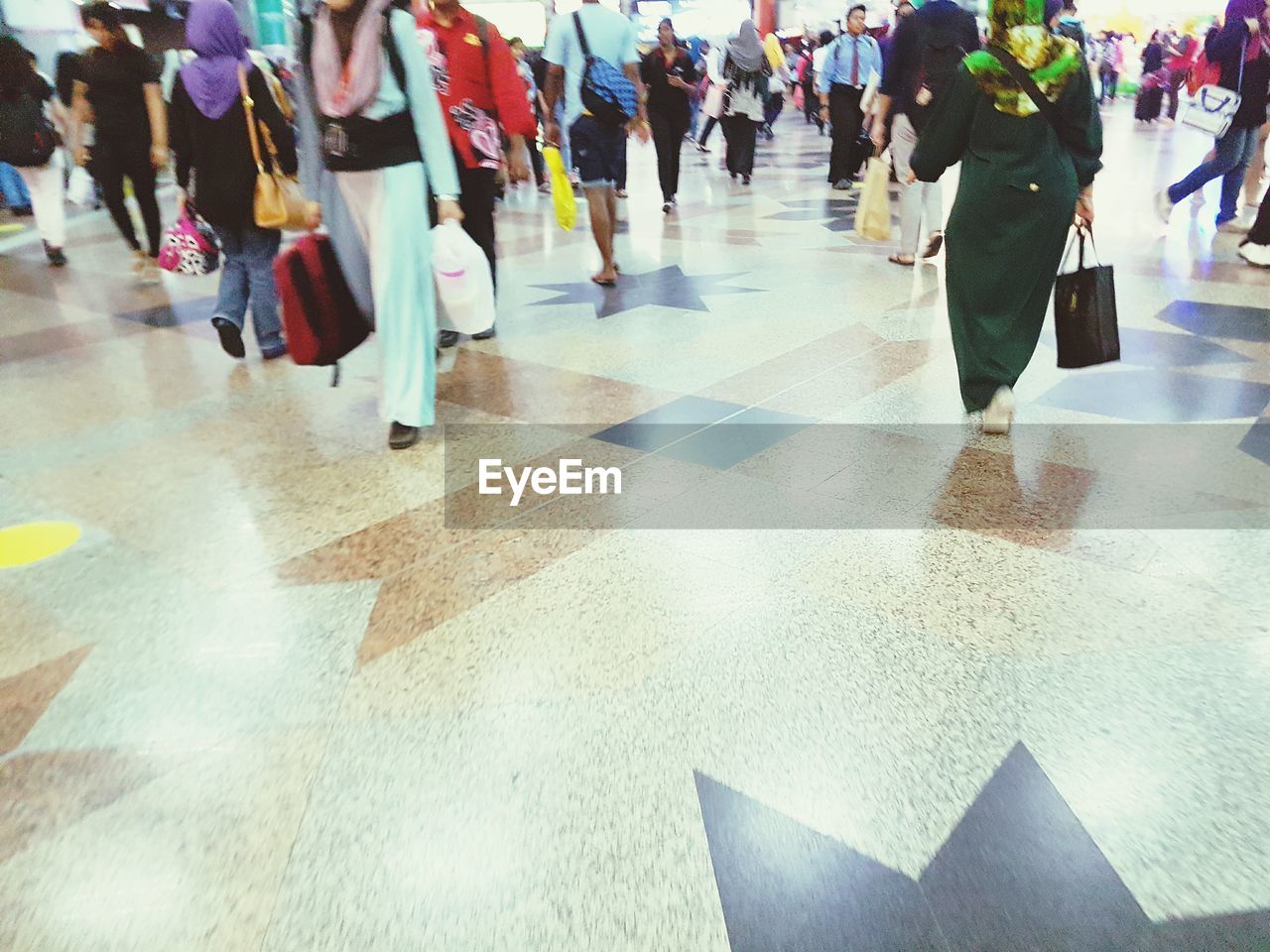 LOW SECTION OF PEOPLE STANDING ON TILED FLOOR