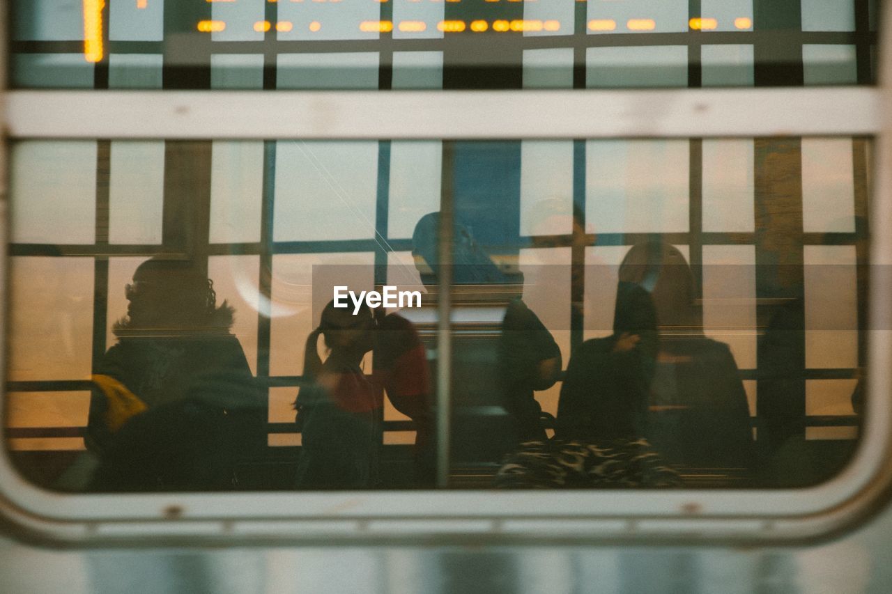 REFLECTION OF PEOPLE ON WINDOW GLASS