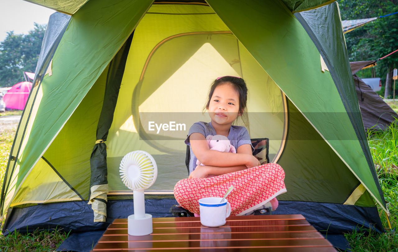 Smiling girl sitting in tent
