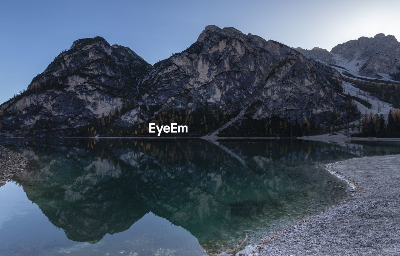 Scenic view of lake by snowcapped mountains against sky