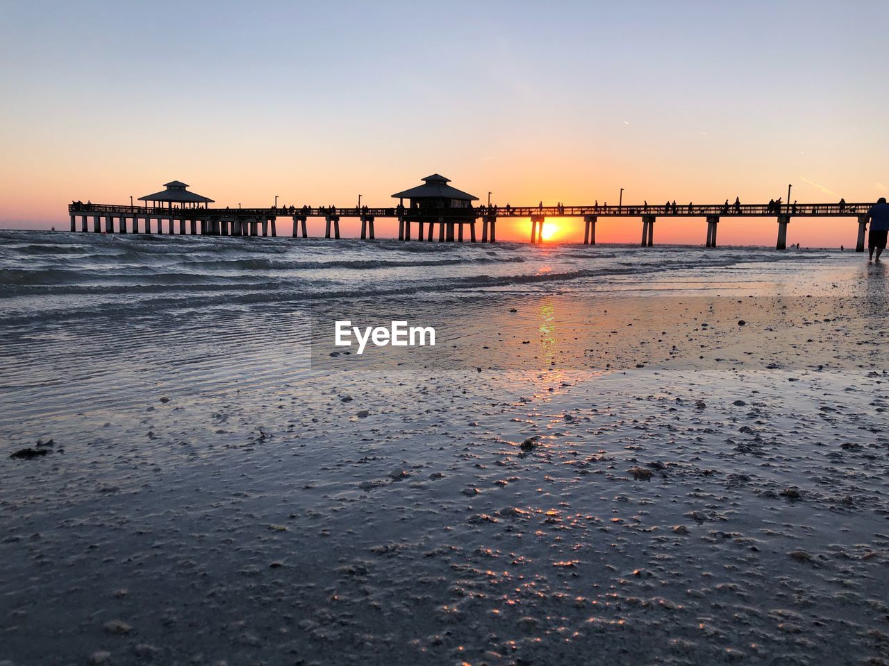 Pier over sea against sky during sunset