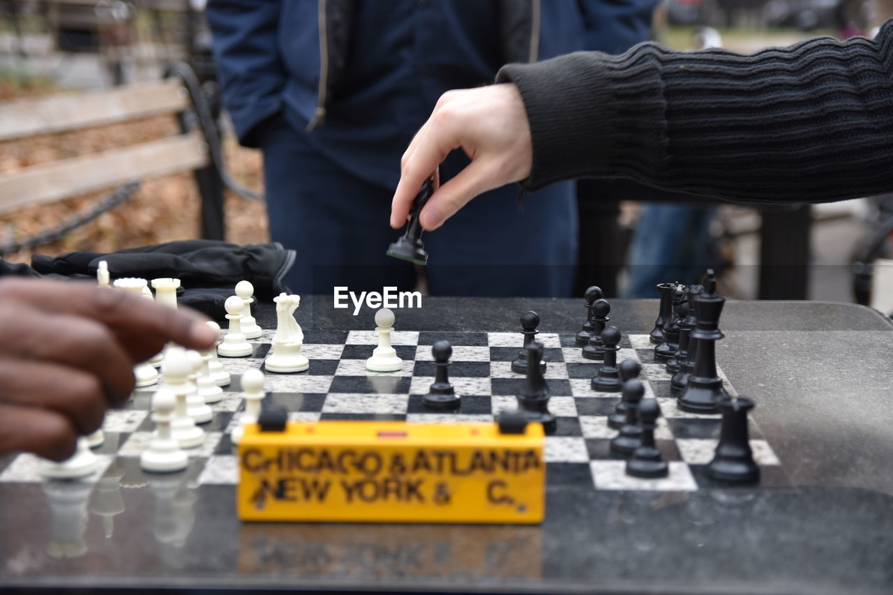 Cropped hands of friends playing chess