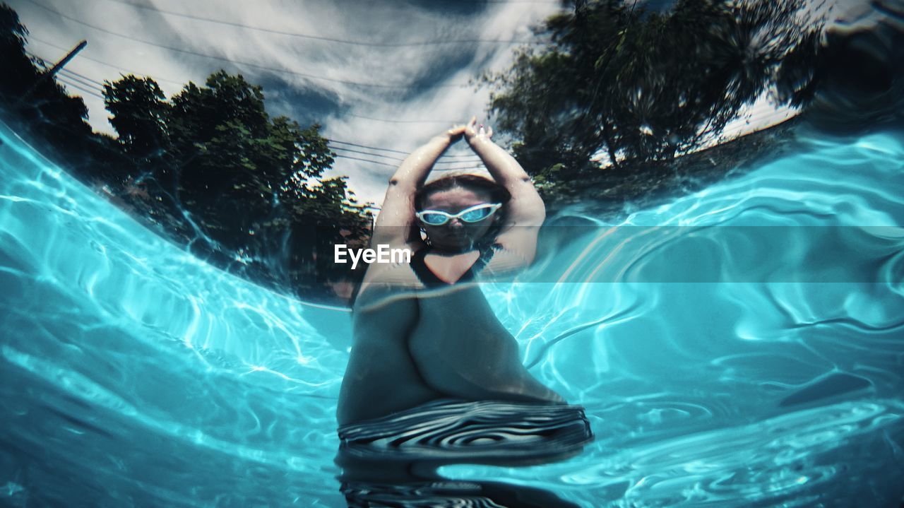 Low angle view of young woman swimming in pool