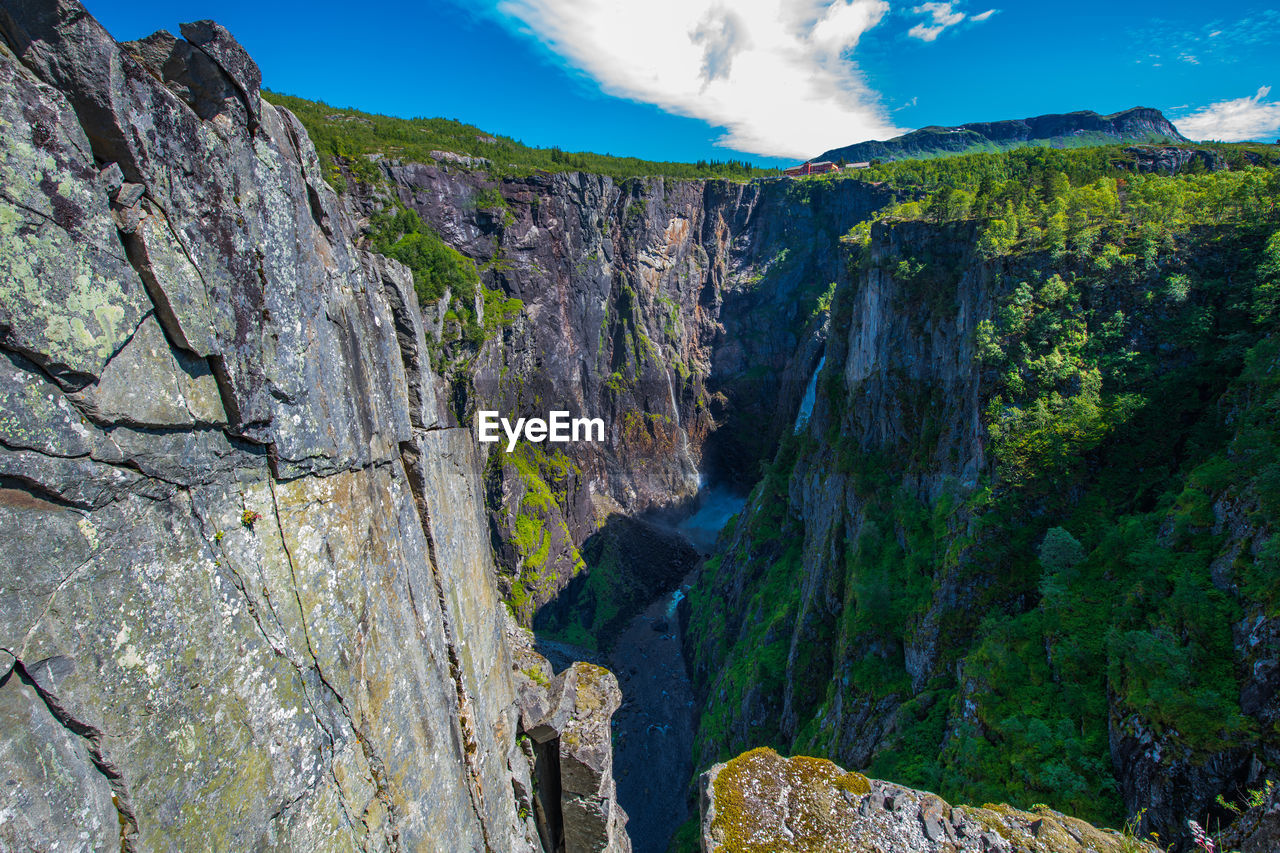 SCENIC VIEW OF WATERFALL AGAINST SKY