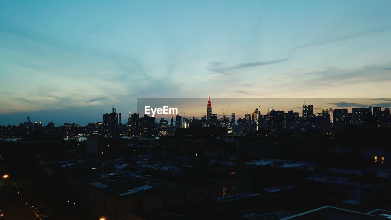 Buildings in manhattan against sky at dusk