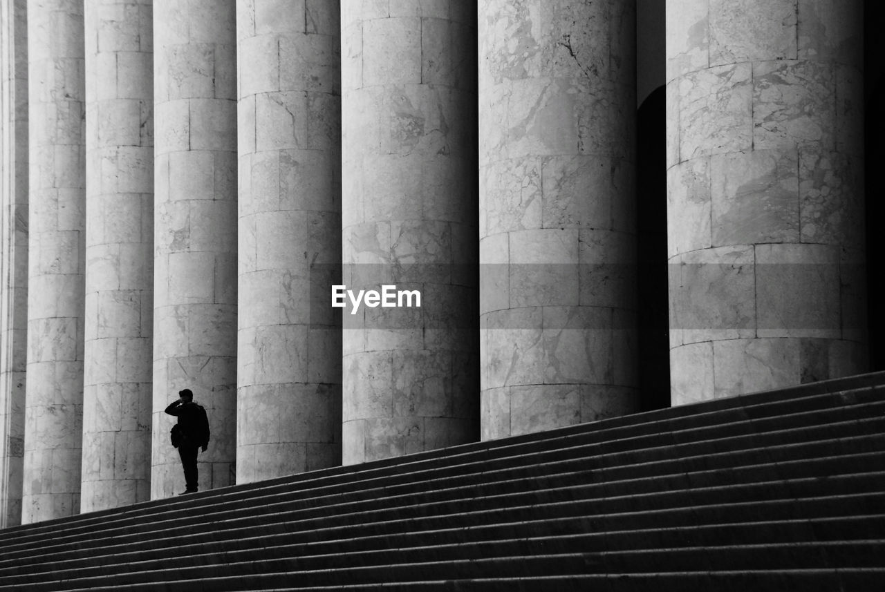 Rear view of man and woman walking on staircase