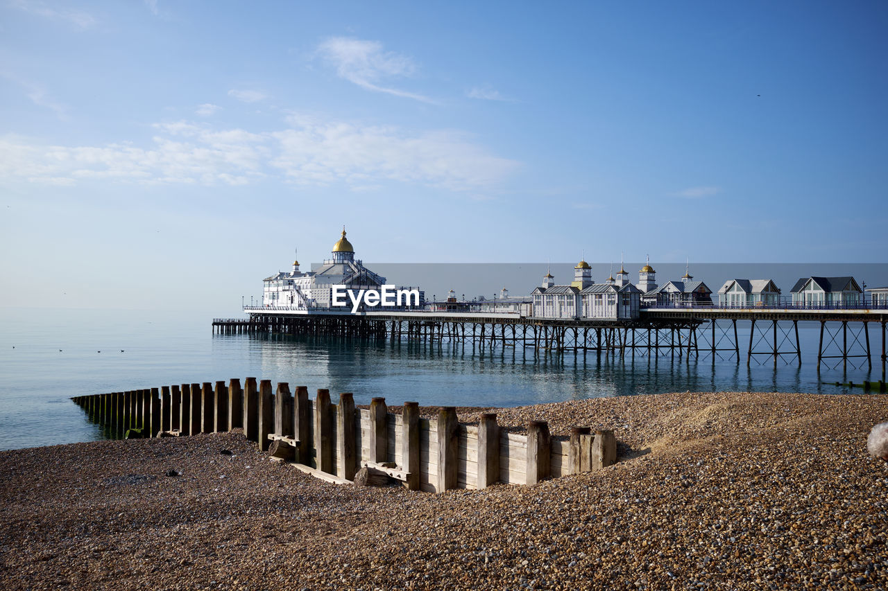 Eastbourne seafront and pier, east sussex, england. a low angle view across the pebbles on the beach