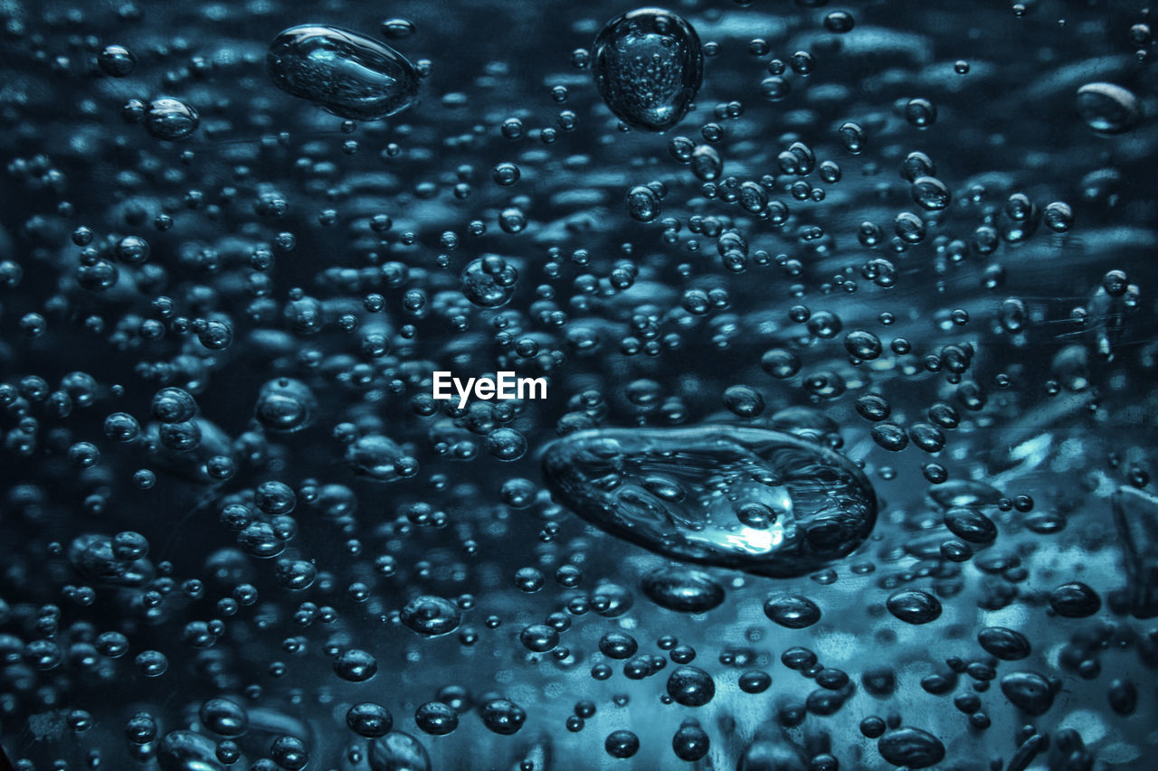 FULL FRAME SHOT OF WET GLASS WITH RAIN DROPS