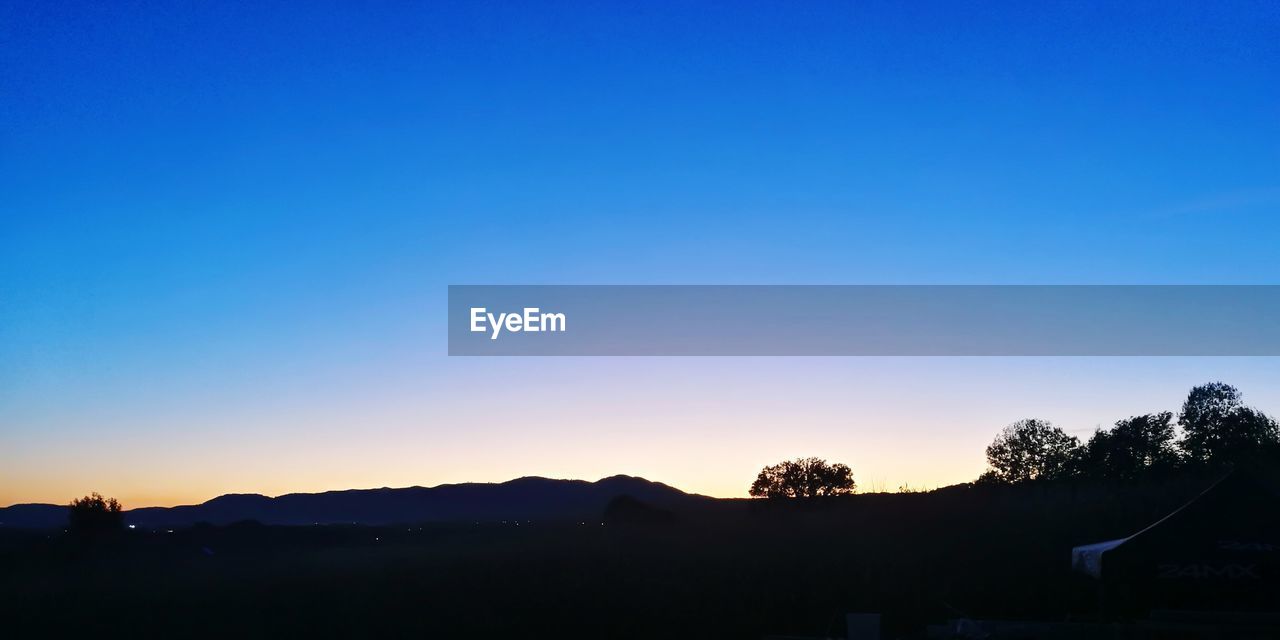 SCENIC VIEW OF SILHOUETTE TREES AGAINST CLEAR SKY