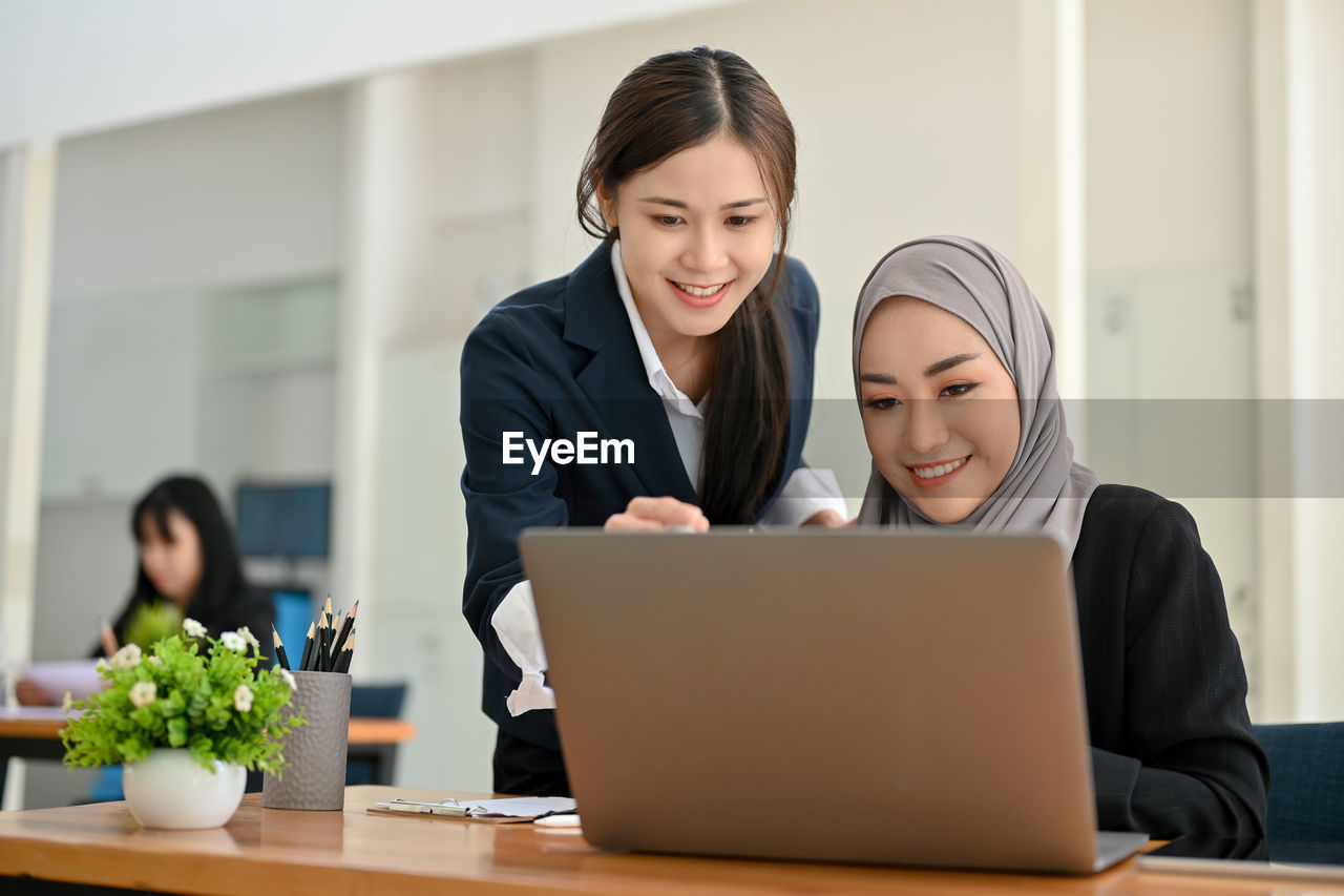 businesswoman using laptop while sitting at office