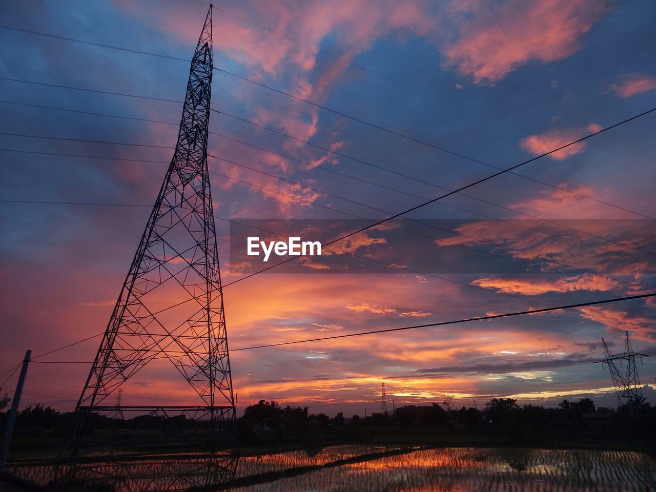 sky, electricity, cable, cloud, technology, sunset, electricity pylon, power supply, transmission tower, power line, power generation, nature, overhead power line, evening, dusk, environment, silhouette, no people, afterglow, landscape, beauty in nature, tower, architecture, scenics - nature, orange color, industry, dramatic sky, outdoors, built structure, business finance and industry, plant, metal, electrical supply, high voltage sign, sunlight, twilight, tranquility, land, steel, tree, alloy