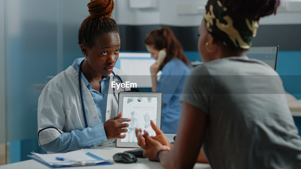 Rear view of doctor examining patient in hospital