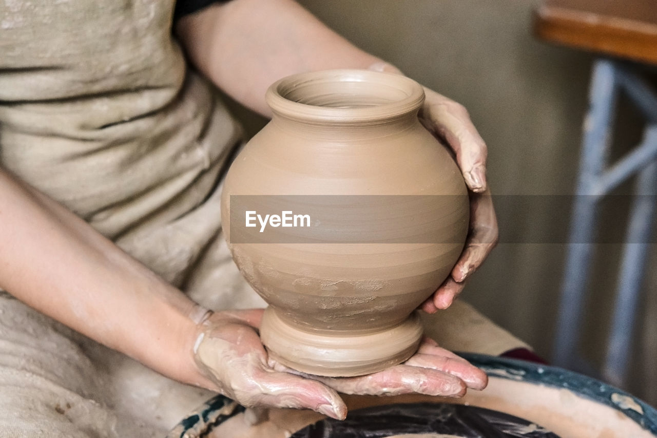 Potter holds just hired by pitcher. ceramic skills. sculptor sculpts products from white clay. 