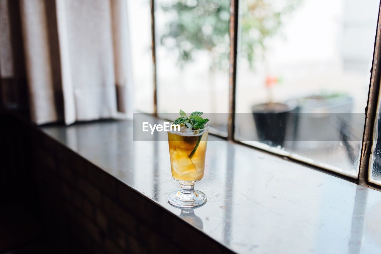 Close-up of drink on window sill