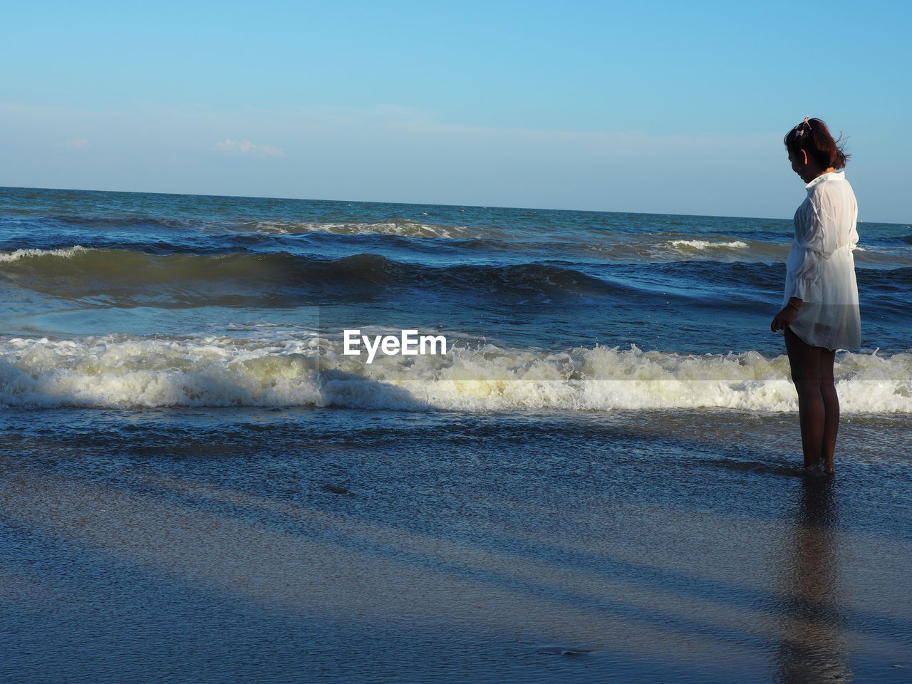 WOMAN STANDING AT BEACH