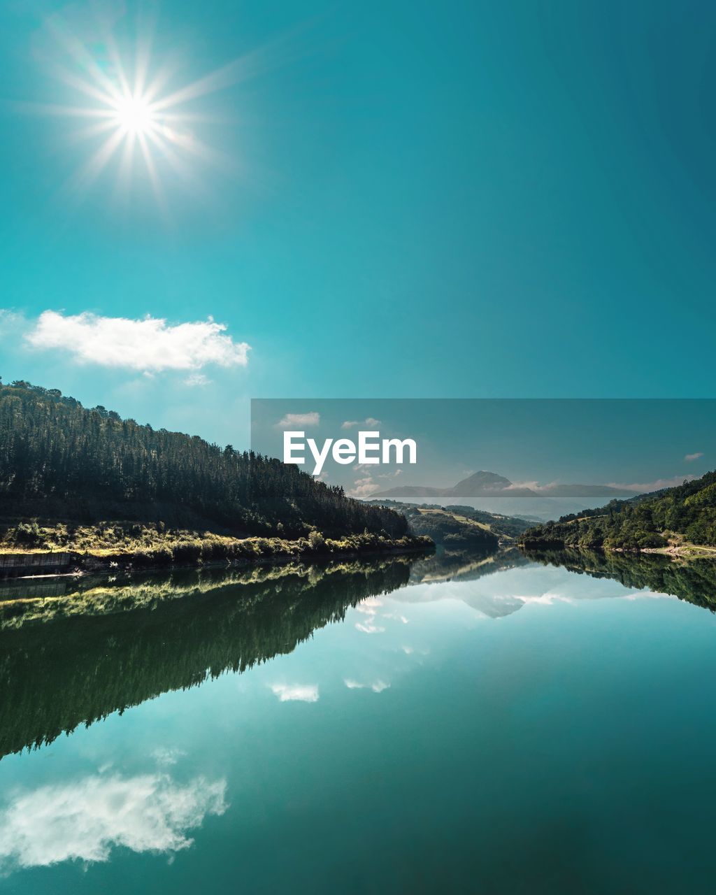 Scenic view of lake and mountains against blue sky