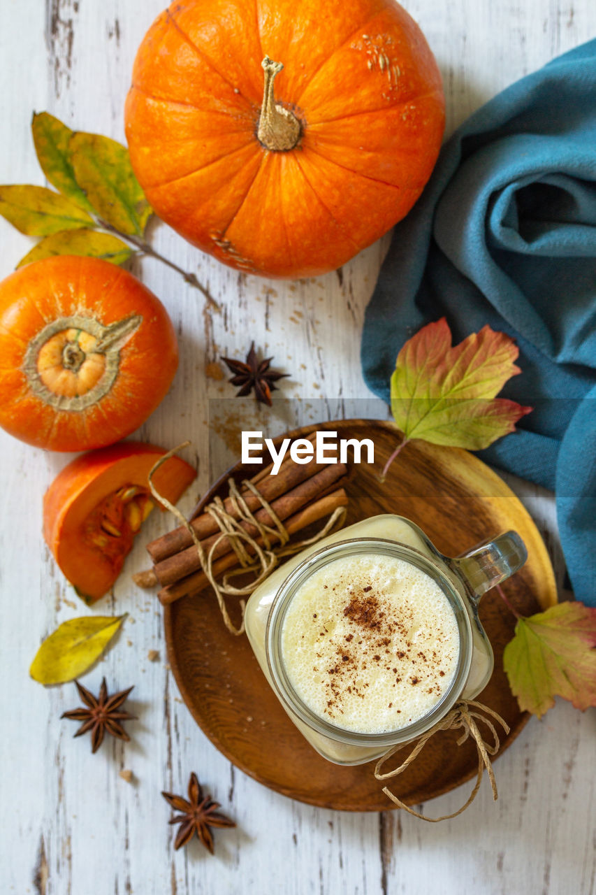 Autumn drink. pumpkin spiced latte or coffee in glass on a rustic wooden table. top view flat lay. 
