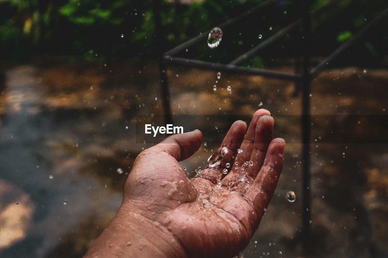 Close-up of hand catching water during rainy season