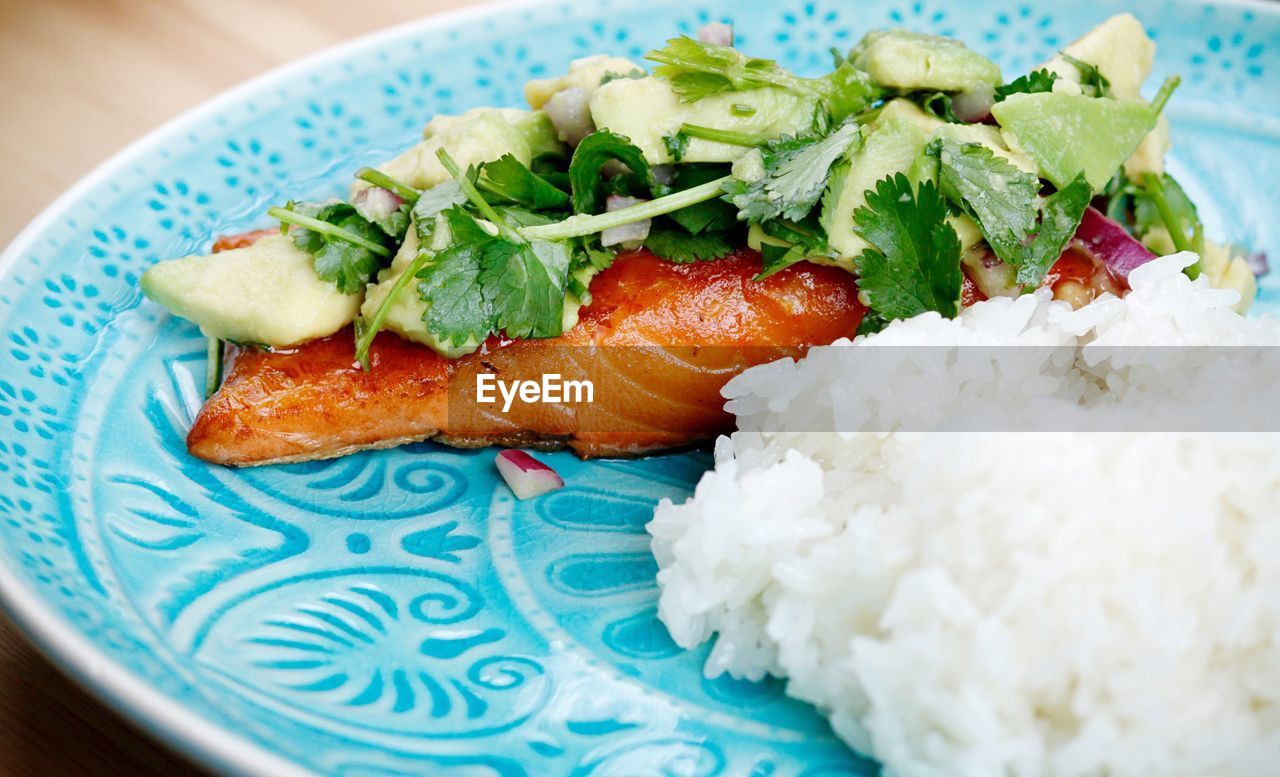 Close-up of salmon filet with avocado and coriander