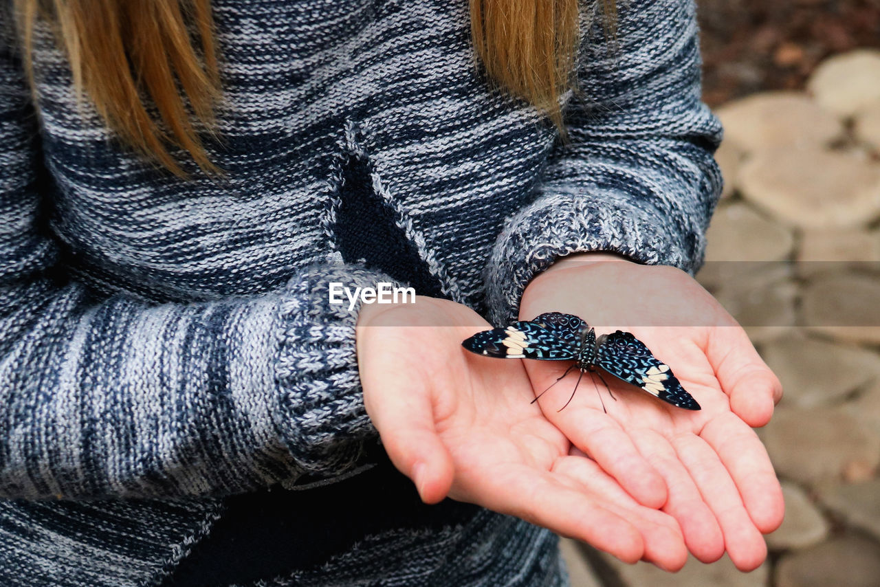 CLOSE-UP OF WOMAN HOLDING HANDS WITH HAIR