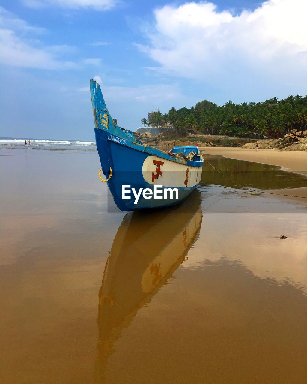 Boat moored on beach against sky