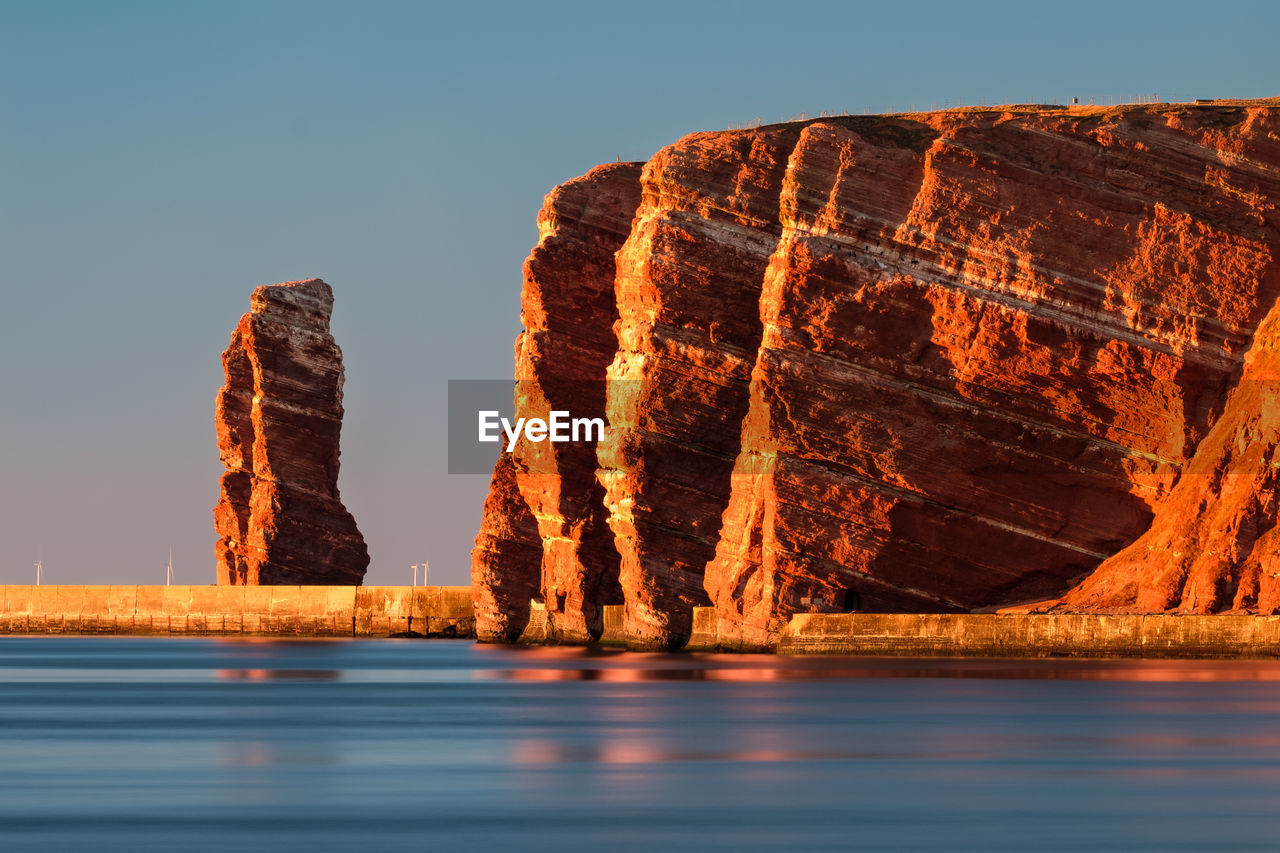 Panoramic view of rock formation in sea against clear sky