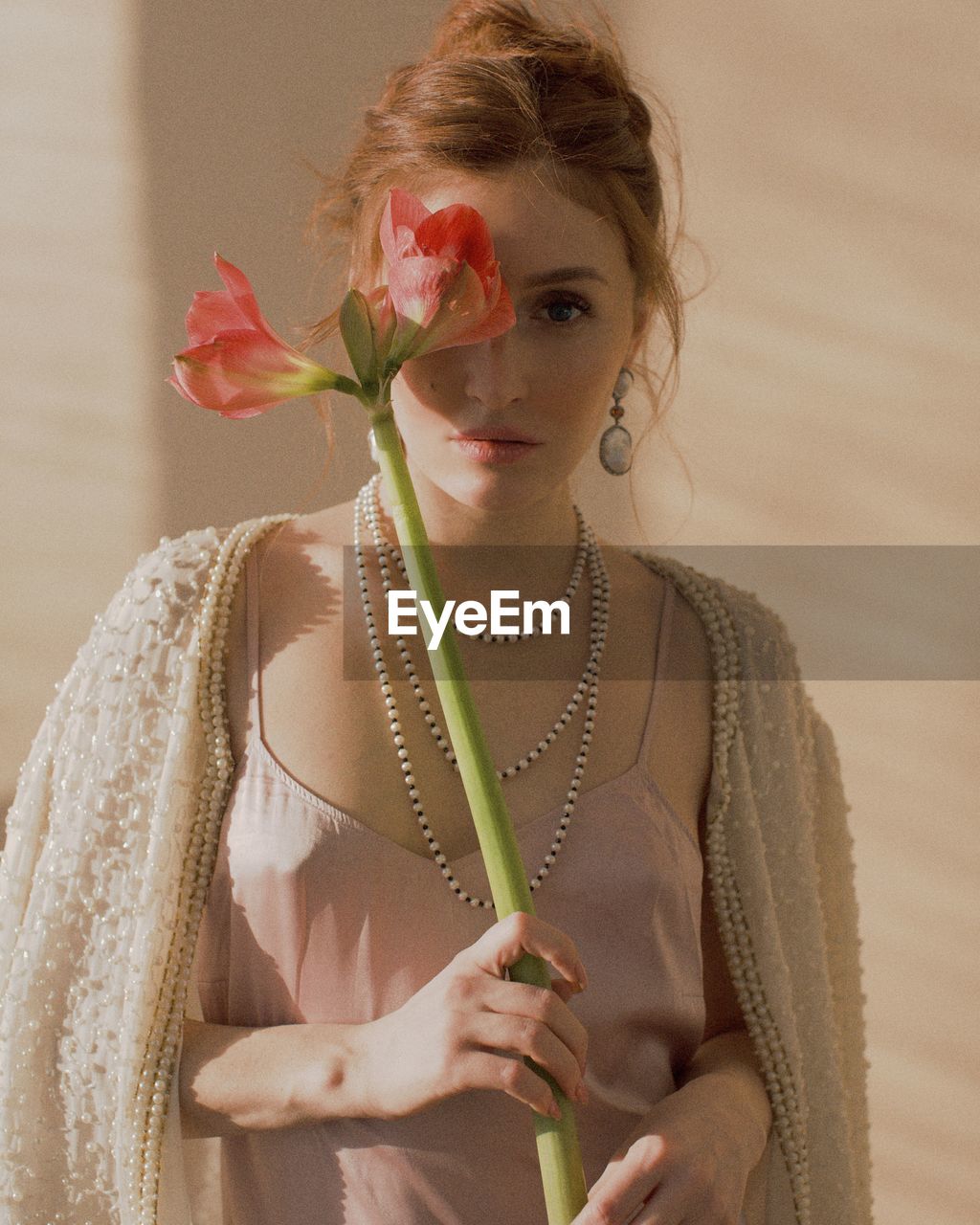 Portrait of woman holding red flowers