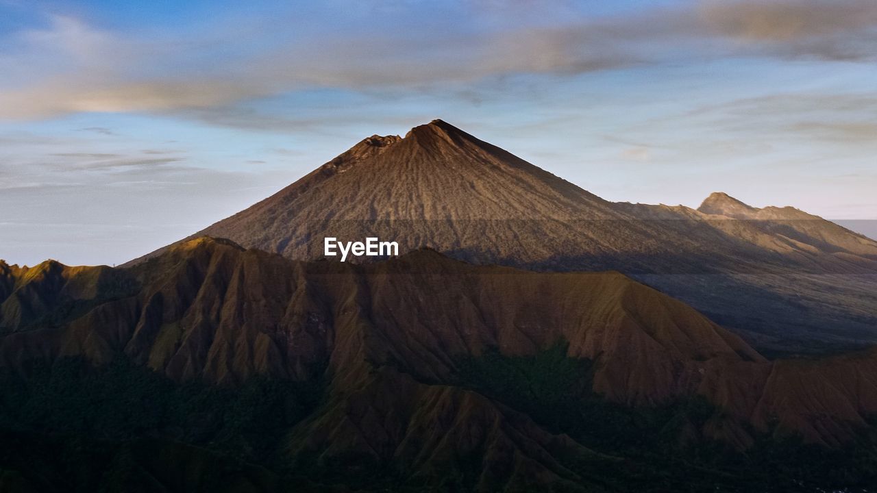 View of volcanic mountain range against cloudy sky