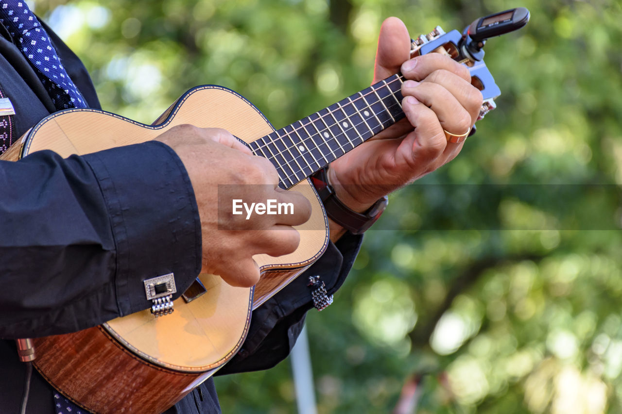 Close-up of man playing guitar outdoors