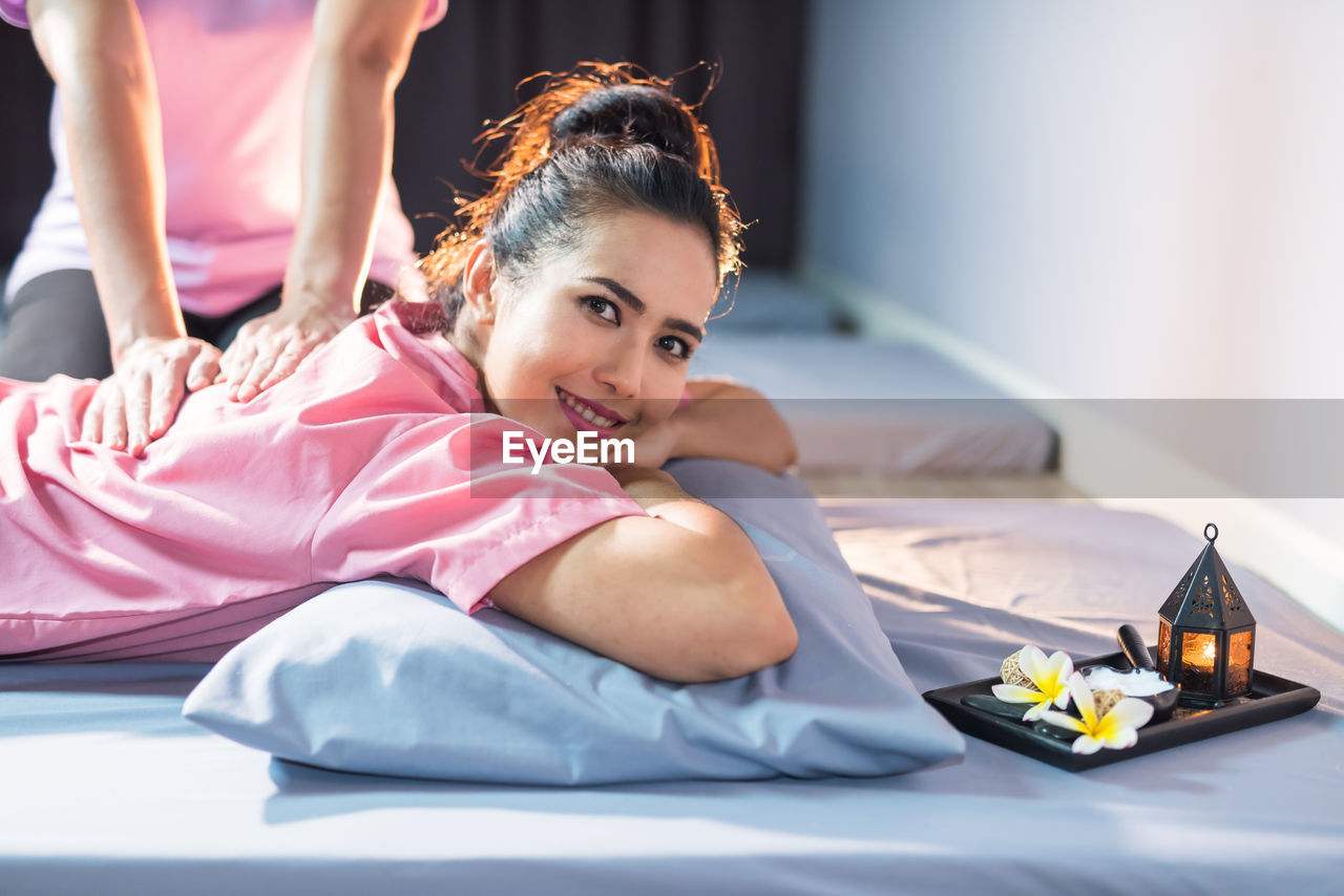 Portrait of smiling woman lying on sofa